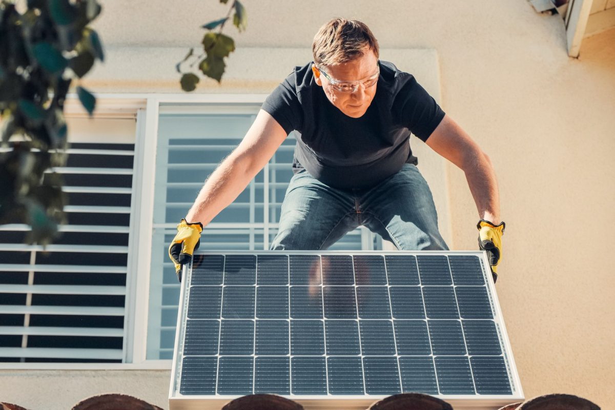 Ouvrier qui installe un panneau solaire sur un toit