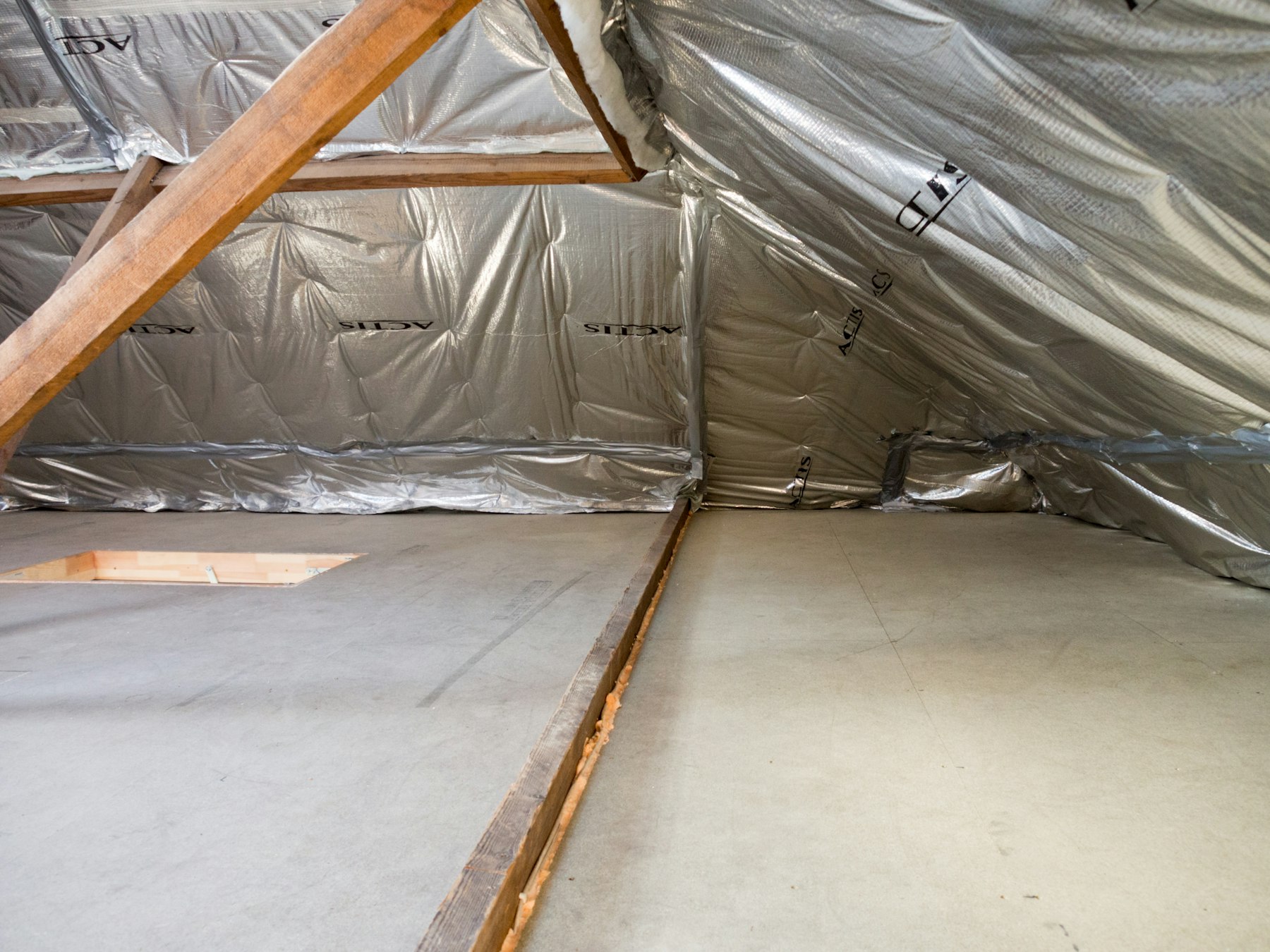 combles d'une maison isolés thermiquement, panneaux isolants posés entre les chevrons de la charpente