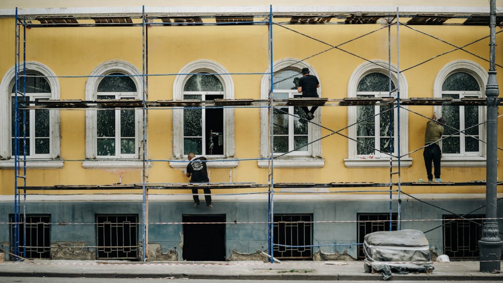 Ouvriers en rénovation sur la façade d'une maison louée