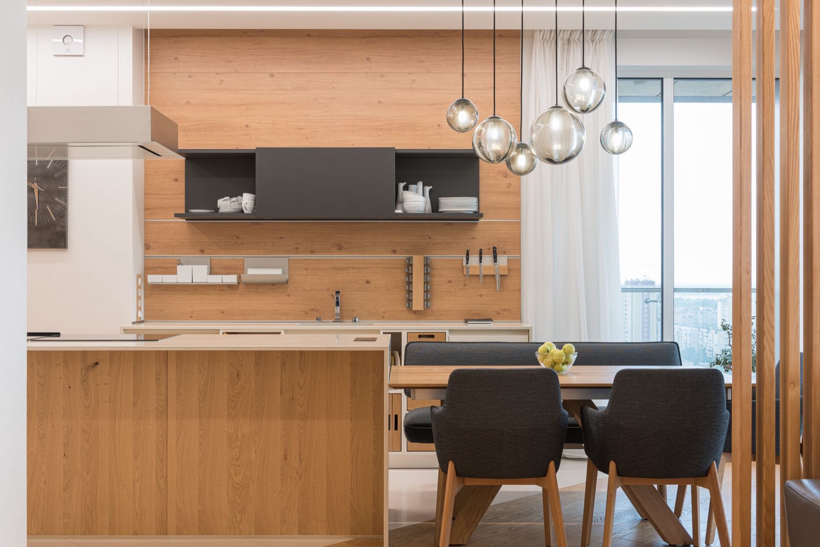 Suspension design au-dessus d'une table de cuisine dans un appartement meublé