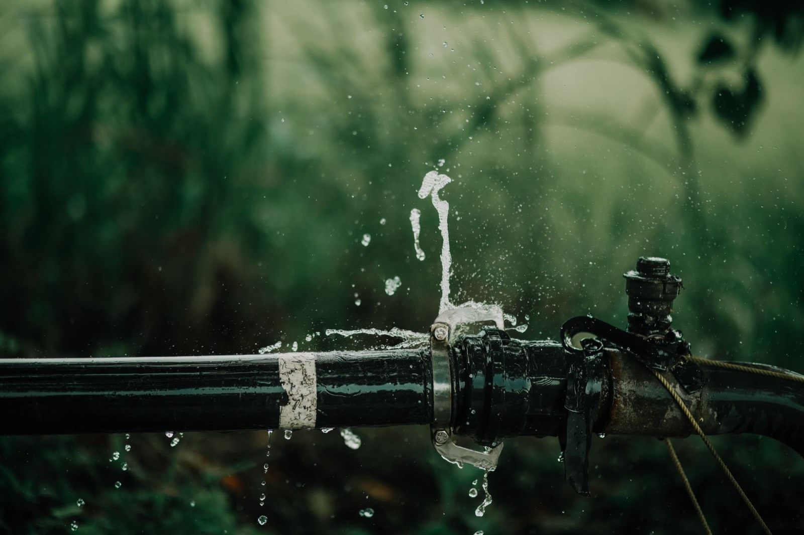 Fuite d'eau près d'une canalisation et outils de plomberie