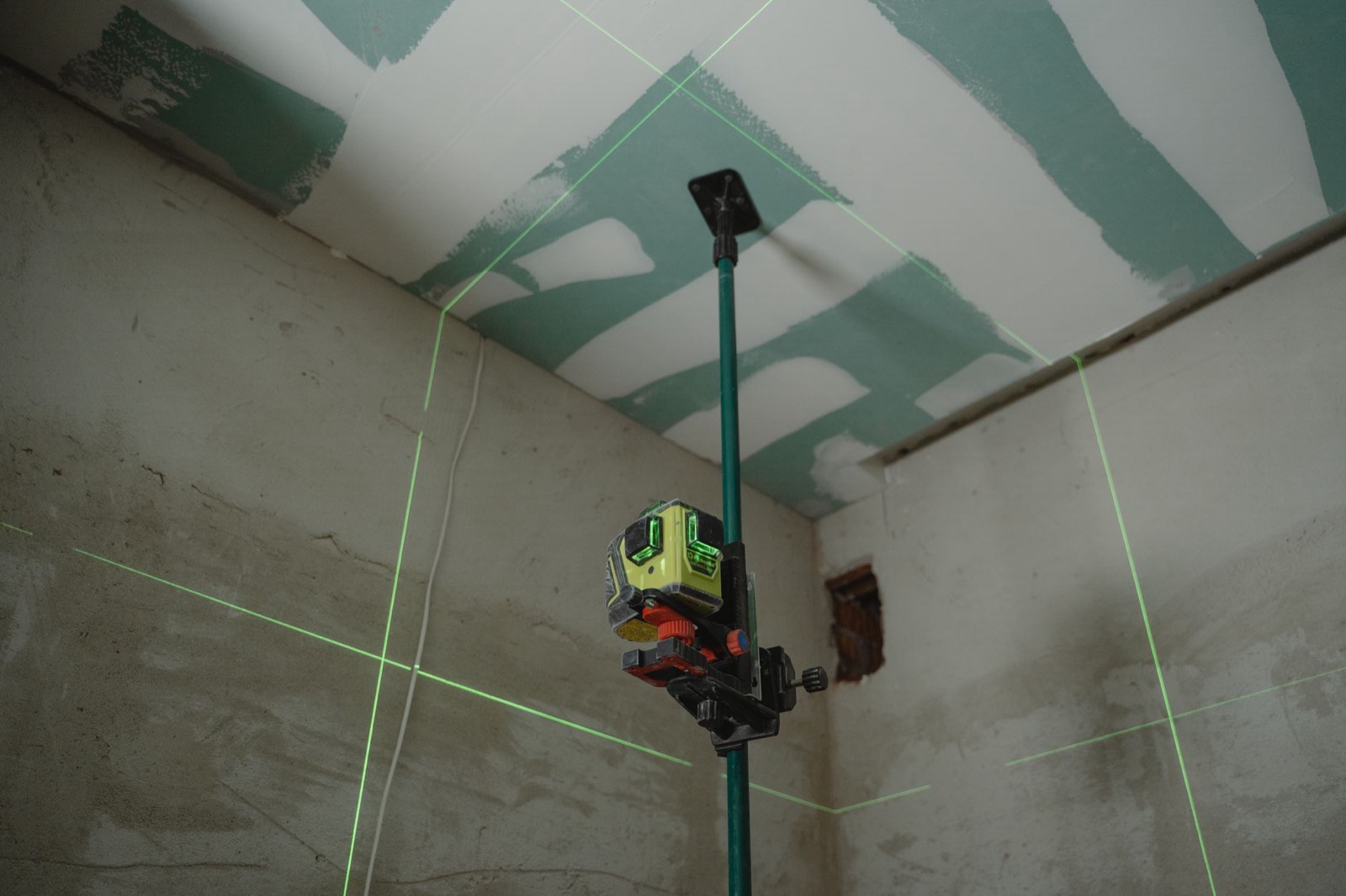 Technicien effectuant un relevé de l'existant avec un appareil de mesure laser avant travaux
