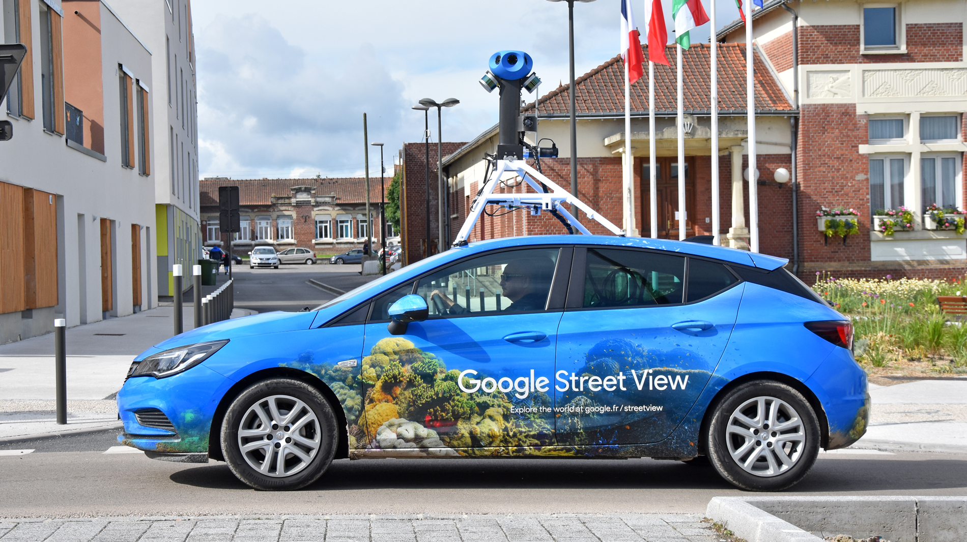 voiture de cartographie Street View équipée d'une caméra sur le toit, roulant devant une mairie de Longueau dans la Somme